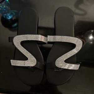 black sandals with a swirl like design in silver rhinestones